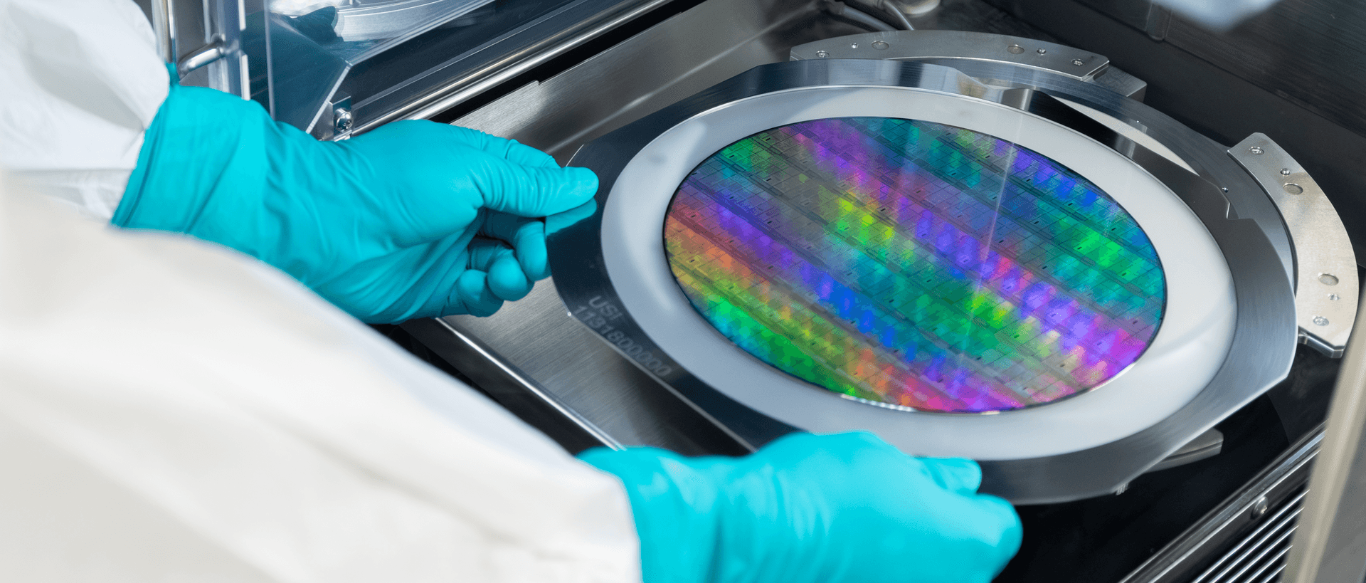 Gloved hands placing a photonic chip wafer into a wafer-handling tool